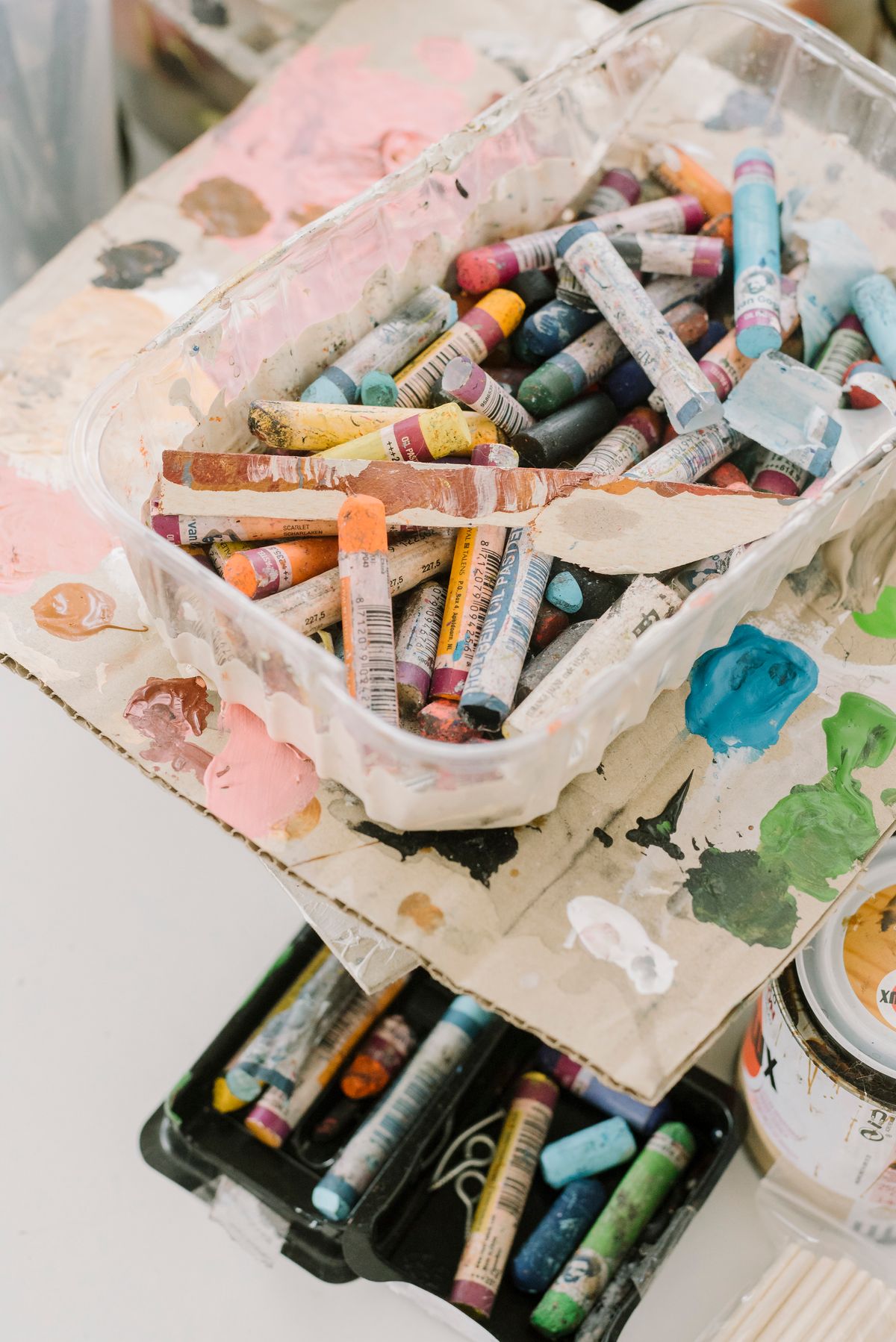 Oil pastels and art supplies spread across a table